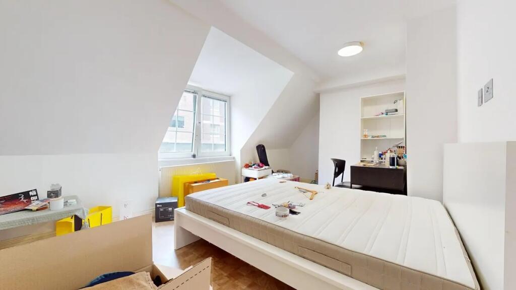 Bright double bedroom with a large window allow...