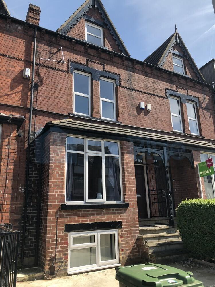A traditional red-brick terraced house with lar...