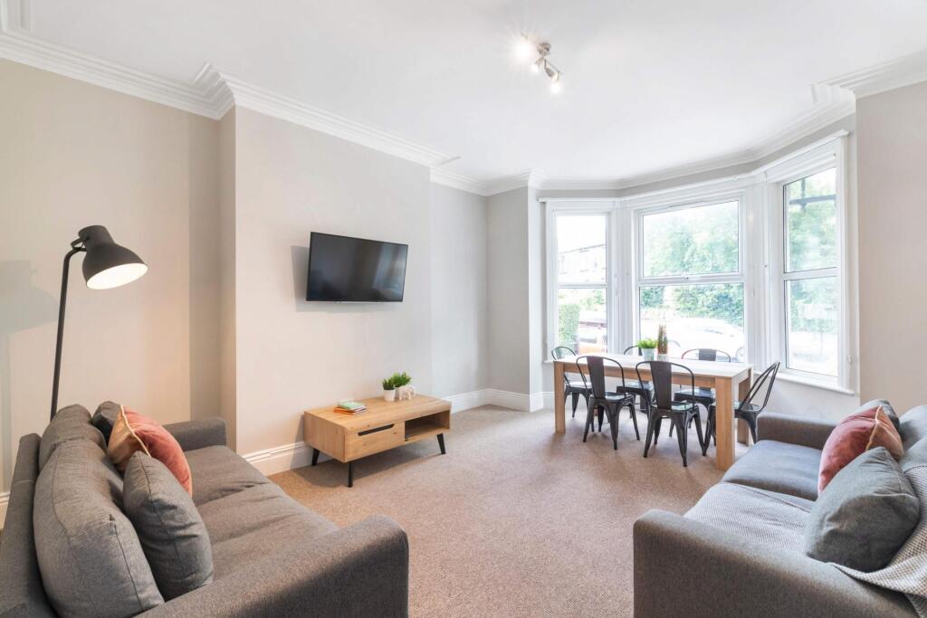 A bright and welcoming living room with large w...