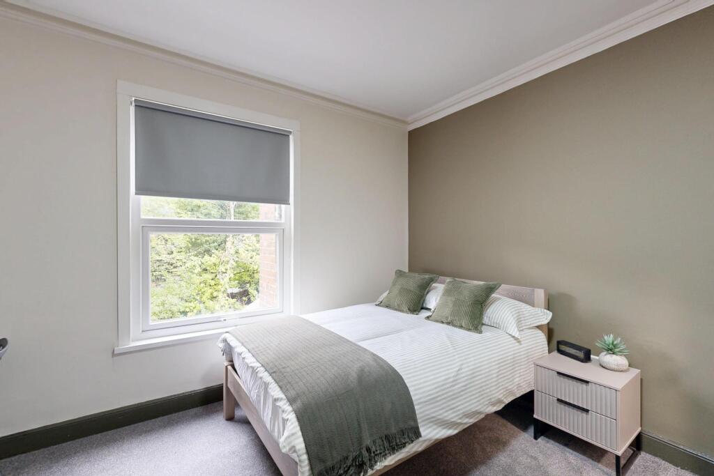 A bright, tidy bedroom with a comfortable doubl...