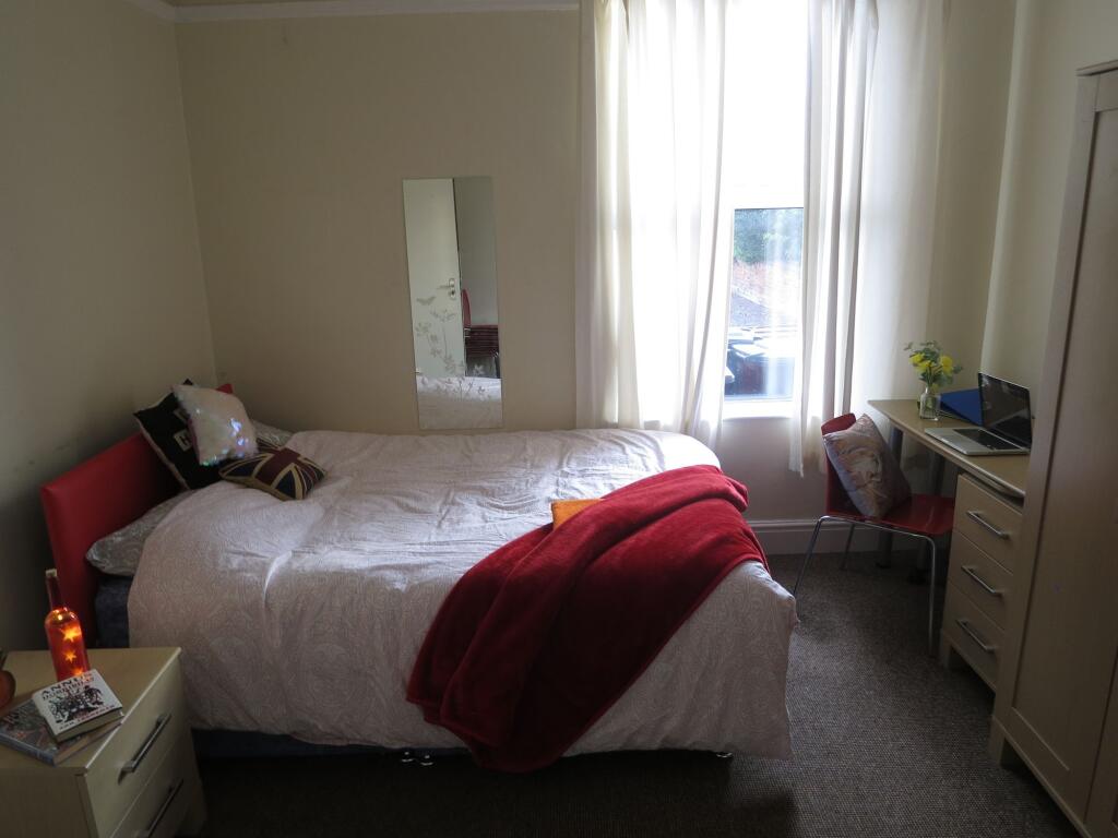 Bright and inviting bedroom featuring a cozy be...