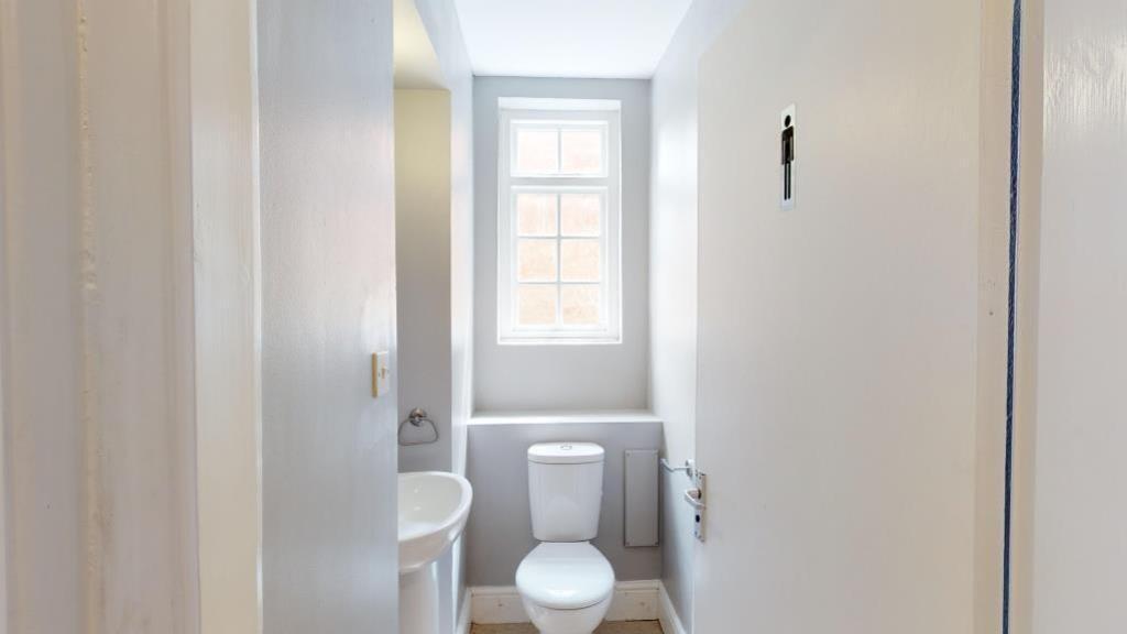 Bright and clean single toilet with a window al...