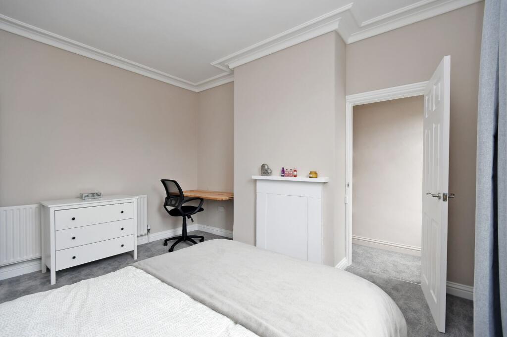 A well-maintained, bright bedroom featuring a n...