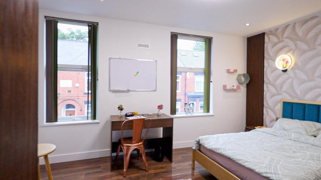 A bright and inviting double bedroom with a stu...
