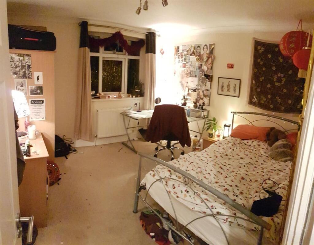 Cozy bedroom featuring a single metal-framed be...