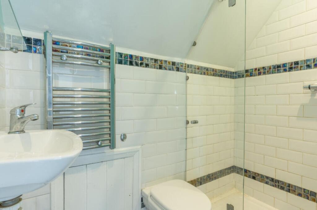 A bright and clean bathroom with a modern showe...