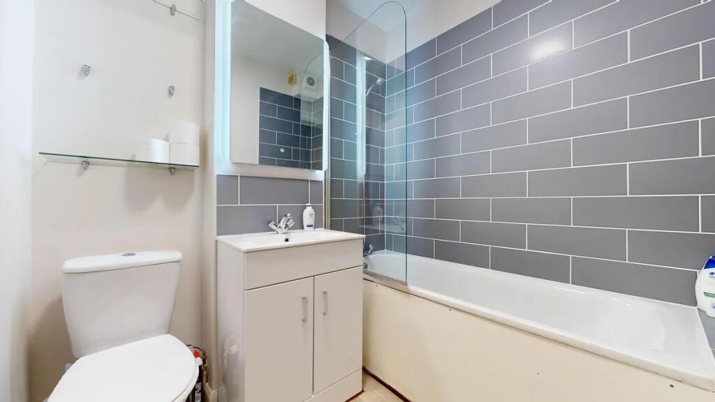 A modern bathroom suite featuring a clean white...