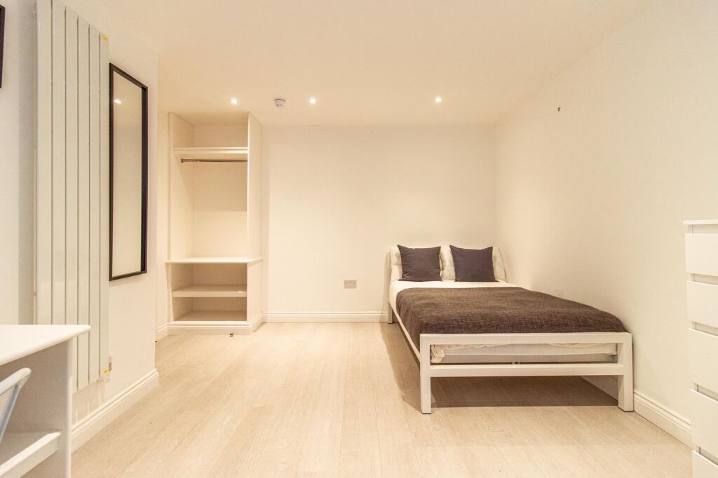 Bright, modern bedroom with neutral decor featu...