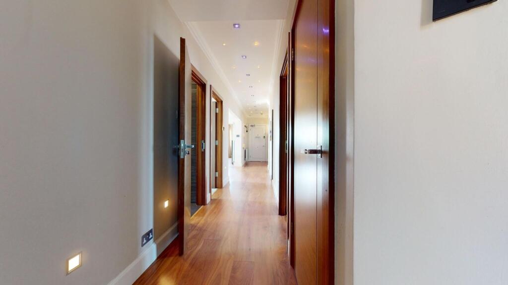 A modern, clean hallway featuring polished wood...