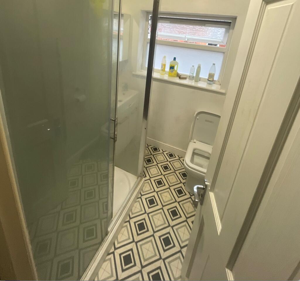 A compact bathroom featuring a walk-in shower w...