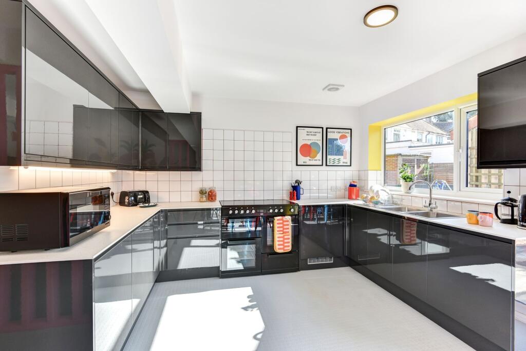 Bright and modern kitchen featuring sleek black...