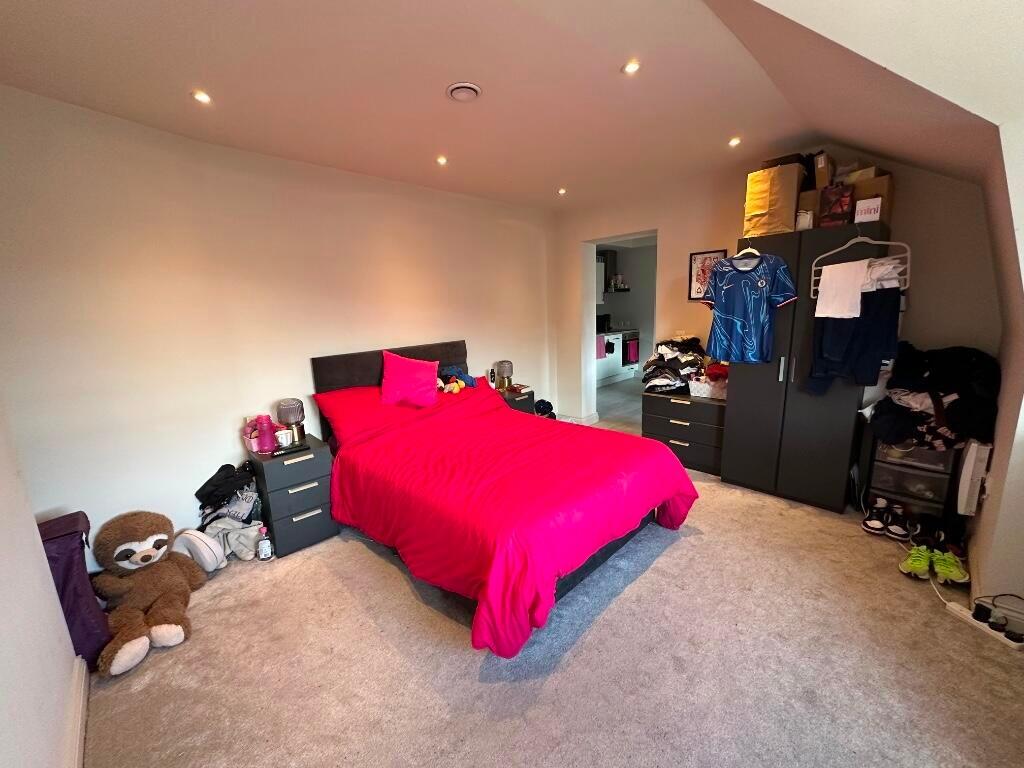 A spacious master bedroom featuring a bold red ...