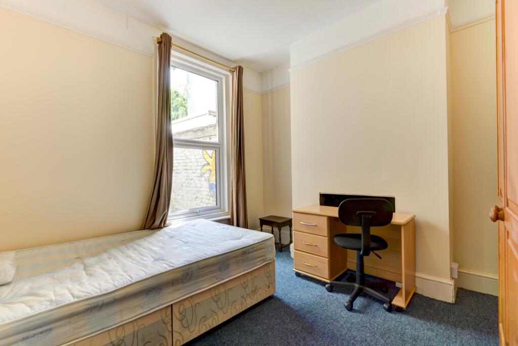 A cozy single bedroom featuring a comfortable b...