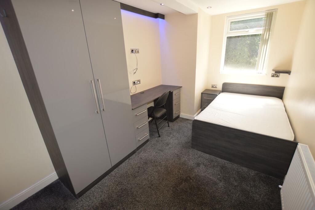 Bright and tidy student bedroom featuring a com...