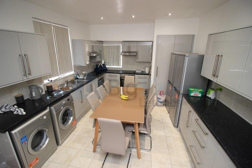 Modern kitchen with sleek black countertops, am...