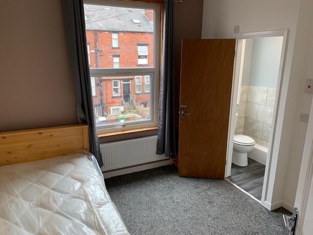 A compact, tidy bedroom featuring a single bed ...