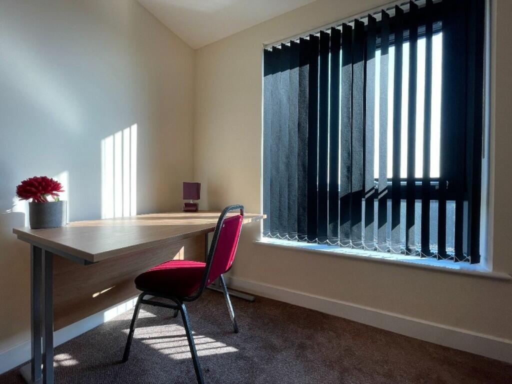 A bright and tidy communal workspace featuring ...
