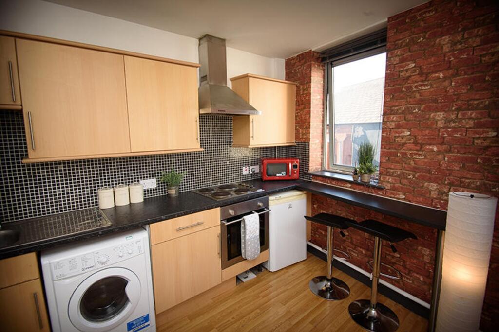 This modern kitchen features stylish wooden cab...