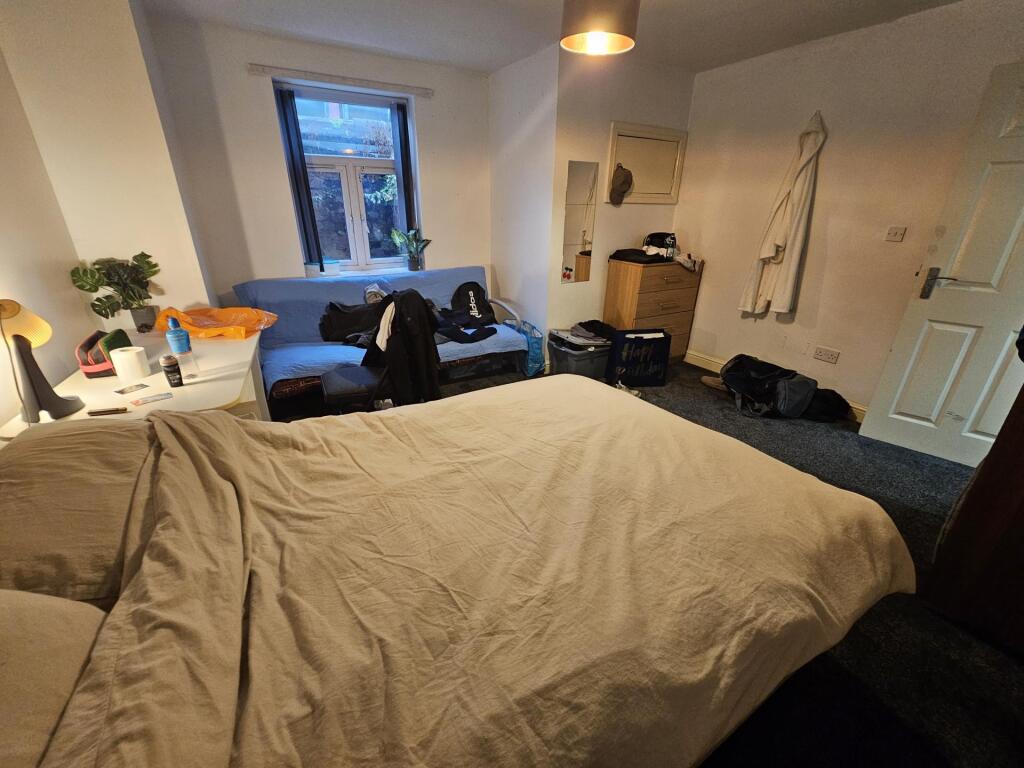 A cozy bedroom featuring a double bed, with nat...