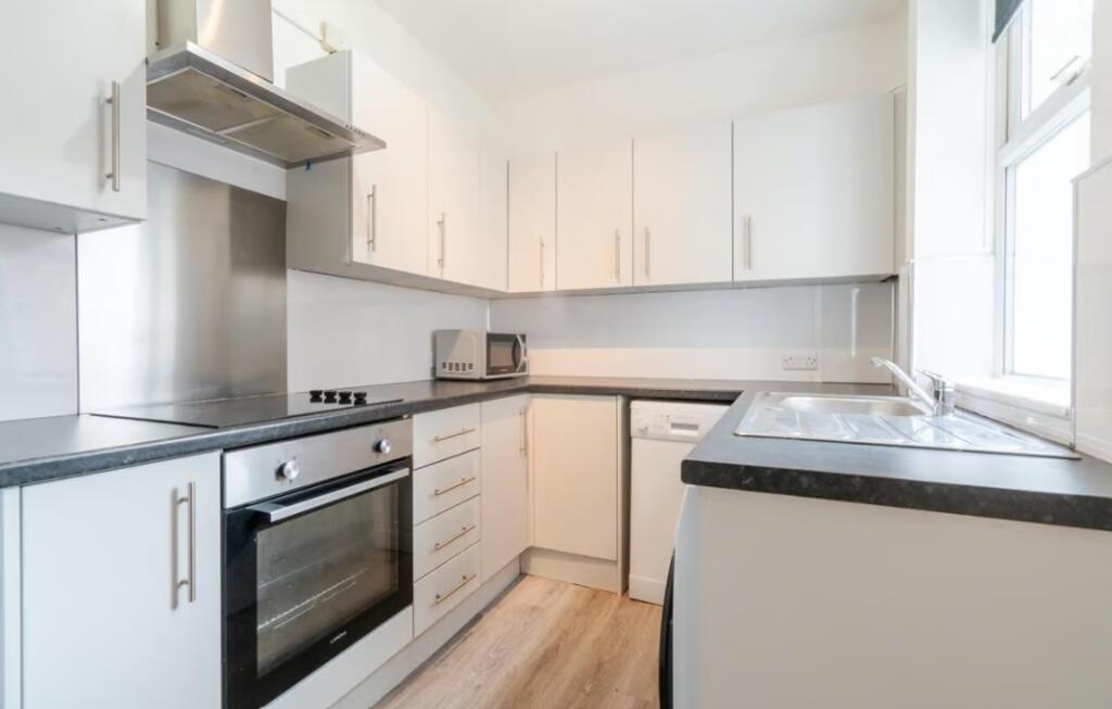 This modern kitchen features sleek cabinetry, a...