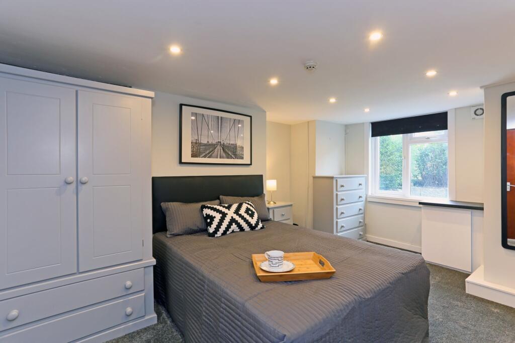 A well-kept double bedroom featuring a comforta...