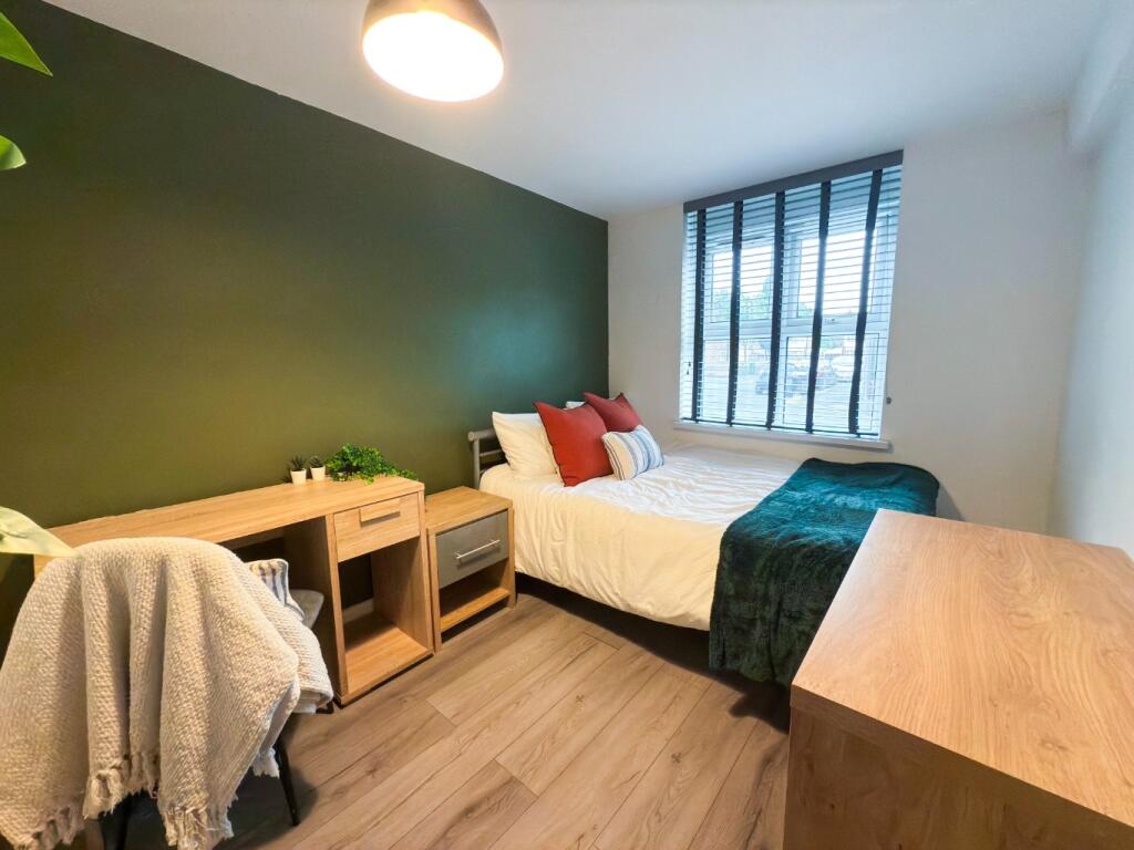 A bright and tidy bedroom featuring a double be...