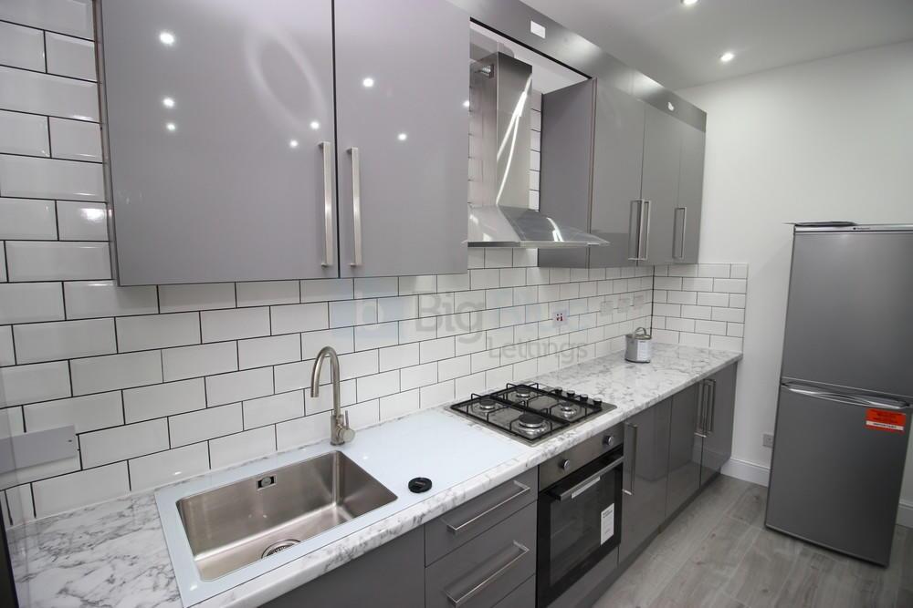A modern kitchen featuring sleek grey cabinetry...