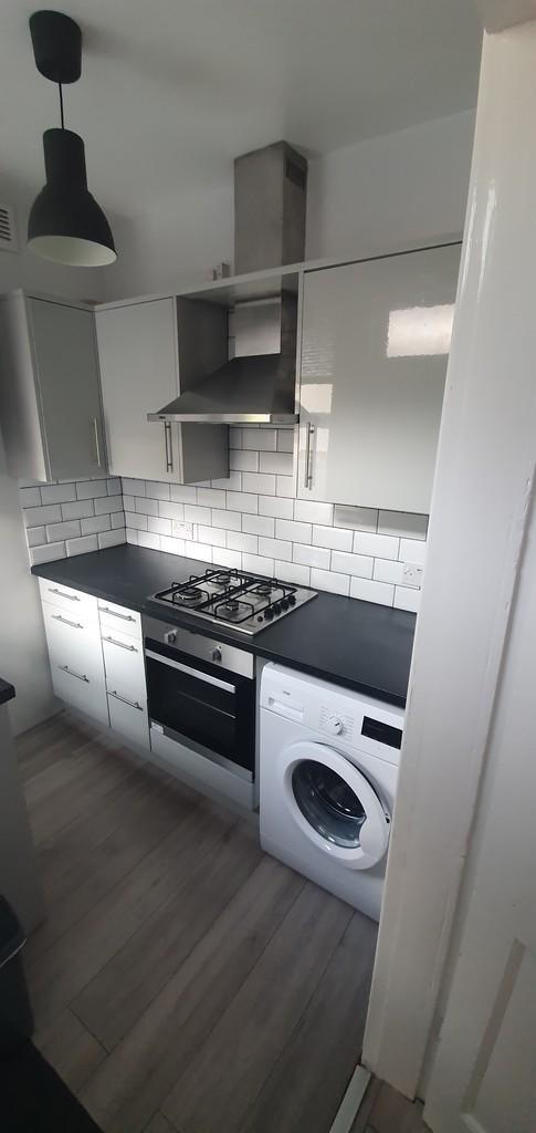 A modern kitchen featuring a sleek gas hob, bui...