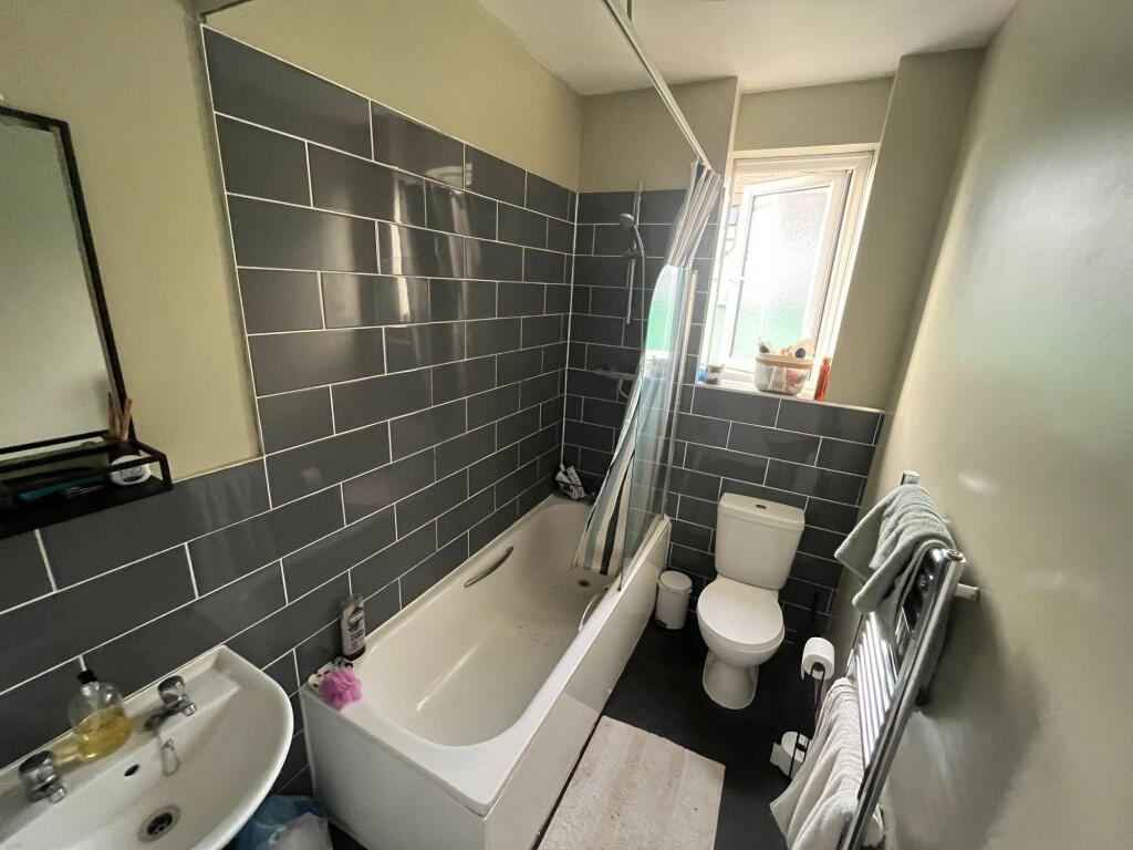 Well-maintained bathroom featuring a white bath...