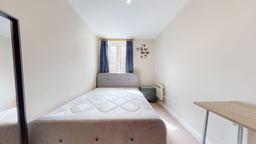 Bright and simple bedroom featuring a comfortab...