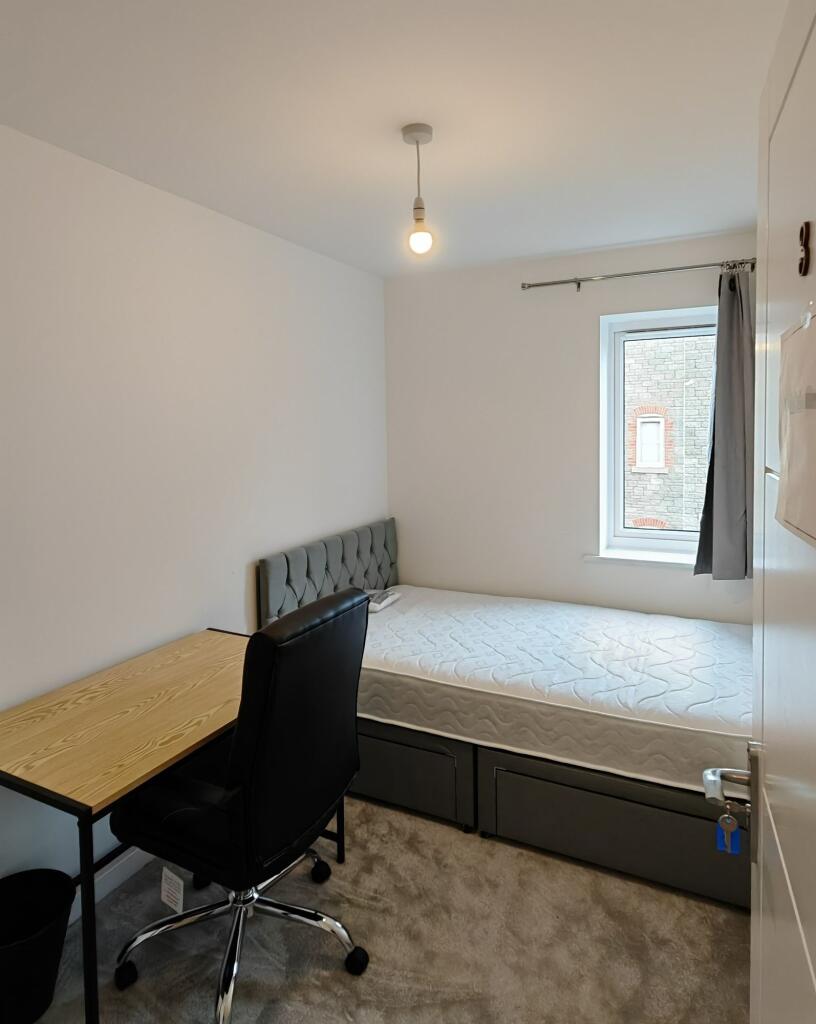 A tidy and simple single bedroom featuring a co...