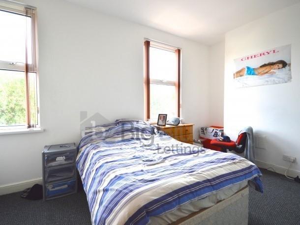Bright double bedroom featuring two large windo...