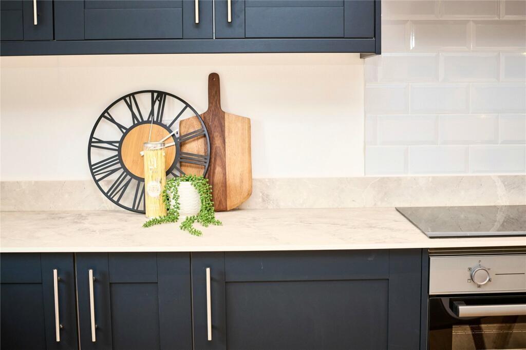 Modern kitchen area featuring sleek dark cabine...