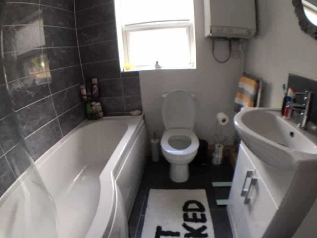 Bright fitted bathroom featuring a modern batht...