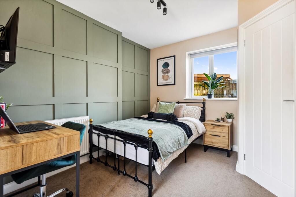 This charming double bedroom features a stylish...
