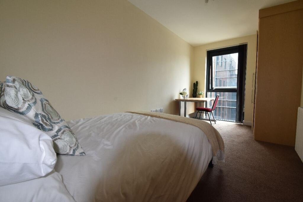A tidy and cozy single bedroom featuring a comf...