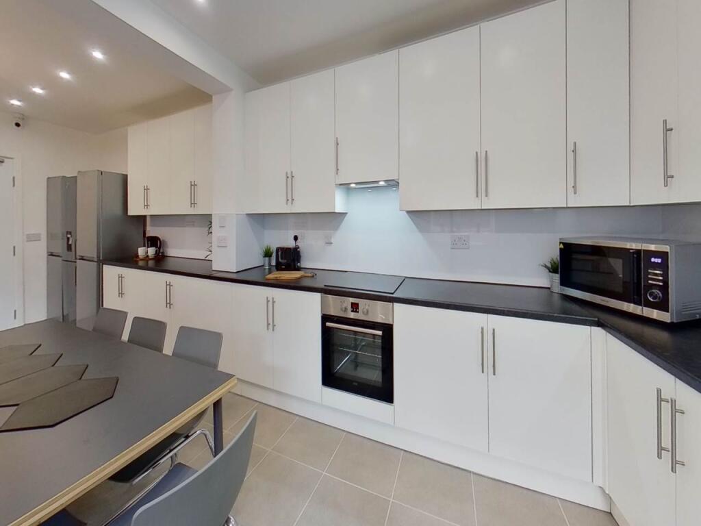 Bright and modern kitchen with ample white cabi...