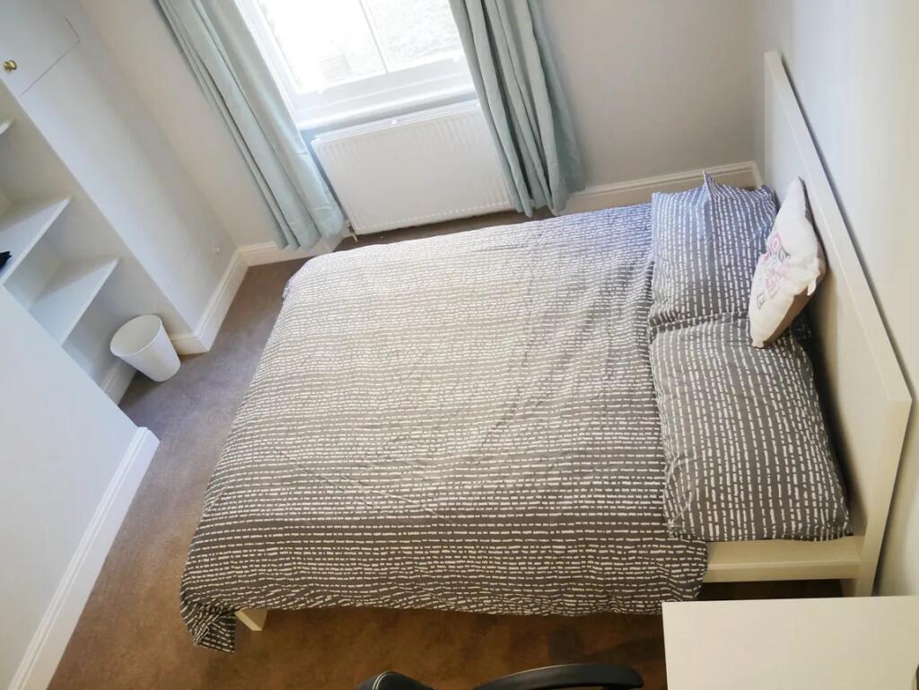 Bright and tidy double bedroom featuring a comf...