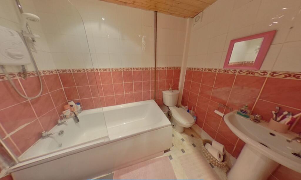 A cozy bathroom suite featuring a bathtub, toil...