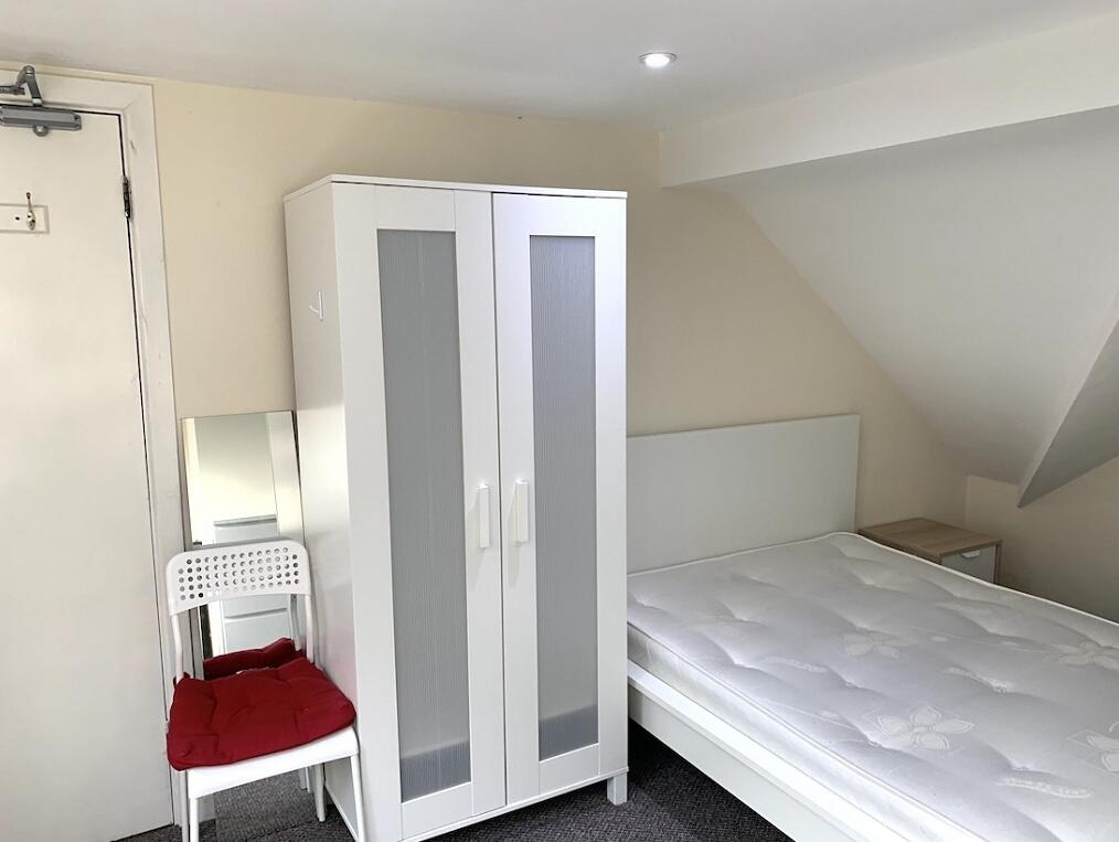 A clean and tidy double bedroom featuring a com...