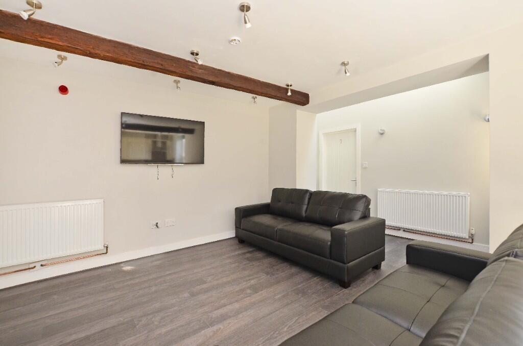 A modern living room featuring two black leathe...