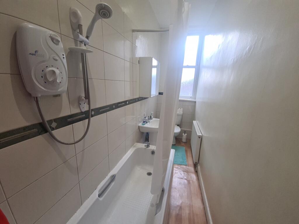 A clean, bright bathroom featuring a bathtub wi...