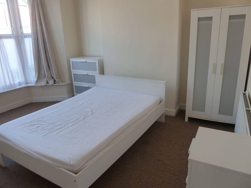 A bright and tidy single bedroom featuring a co...