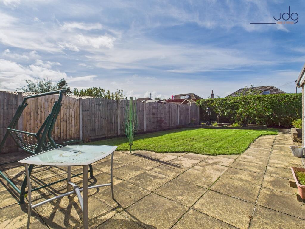 Spacious rear garden with flags and lawn