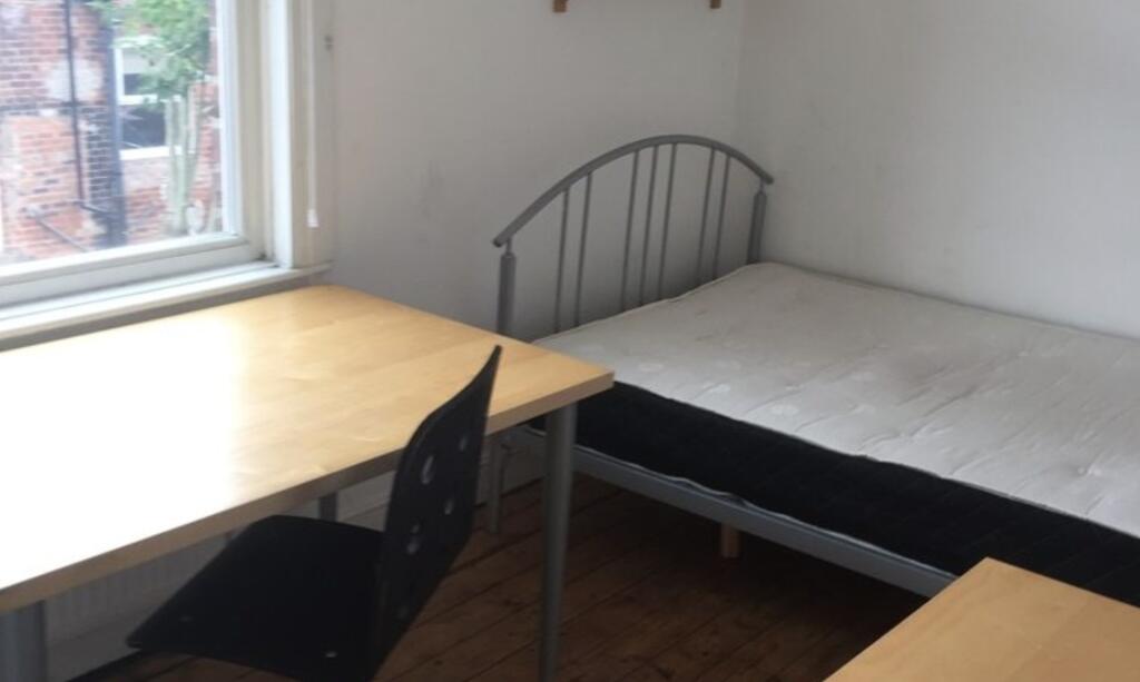 Bright, simply furnished bedroom with a large d...