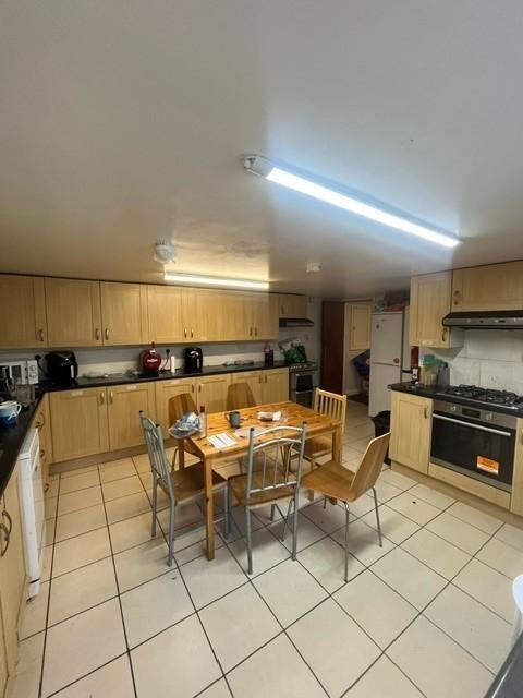 Bright communal kitchen with extensive fitted c...