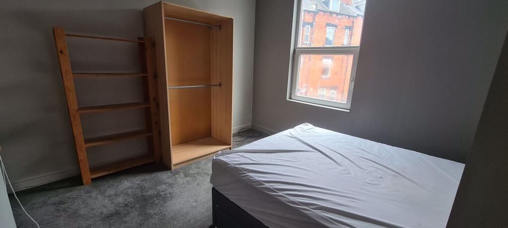 A bright double bedroom featuring a comfortable...