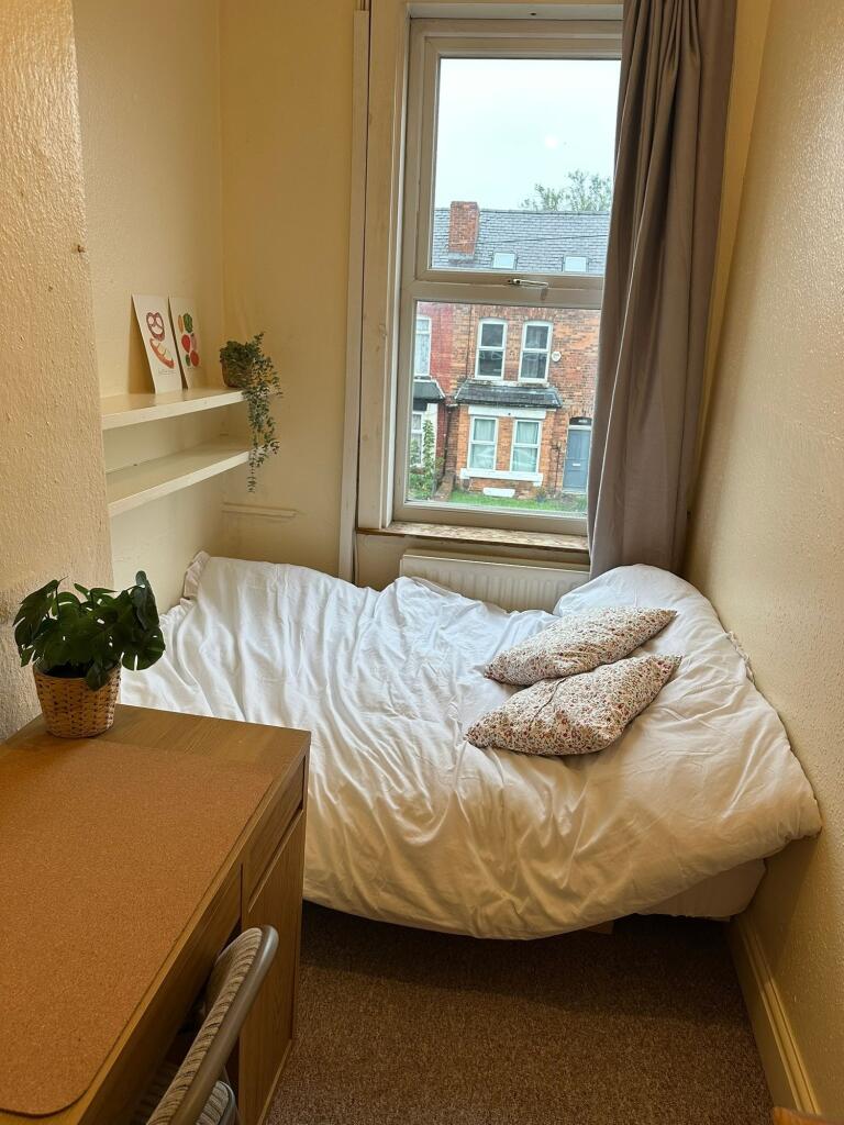 Cozy bedroom with a large window allowing natur...