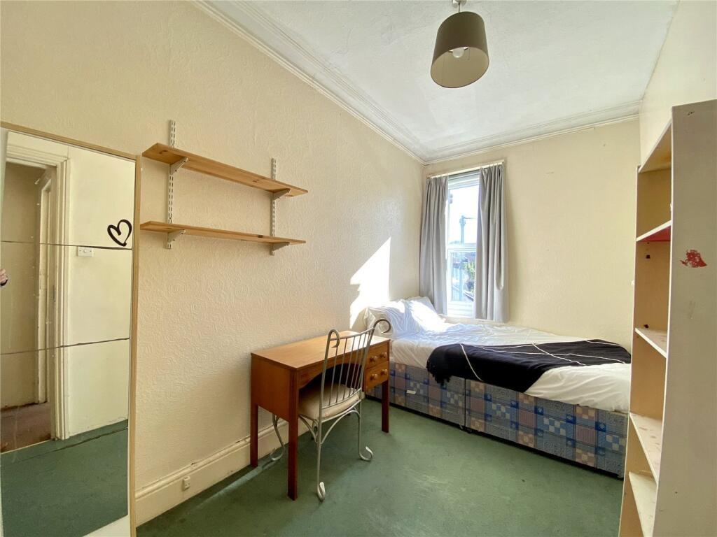 A cozy single bedroom featuring a comfortable b...