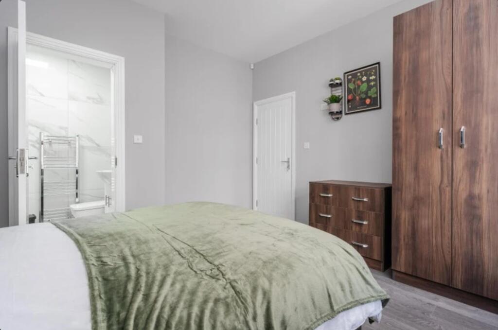 This inviting double bedroom features a cozy gr...